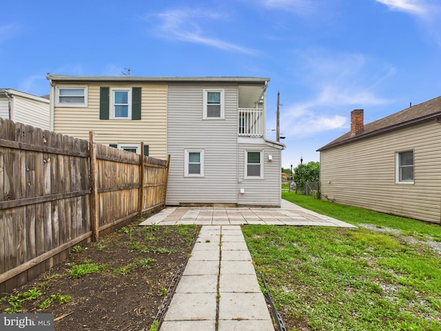 back of house with a yard, a patio, and a fenced backyard