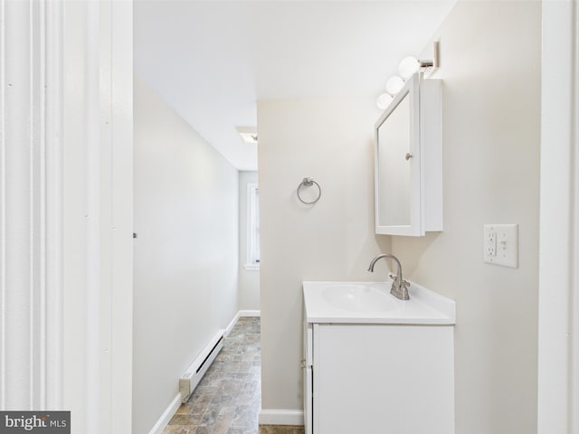 bathroom featuring vanity, baseboards, stone finish floor, and a baseboard heating unit