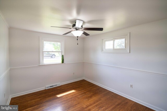 unfurnished room with ornamental molding, baseboards, wood finished floors, and a ceiling fan
