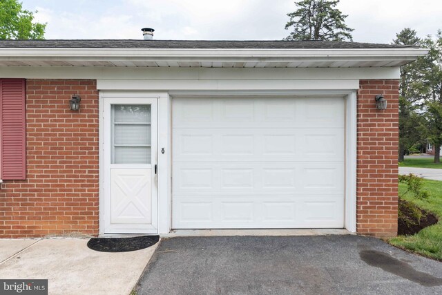 garage featuring asphalt driveway