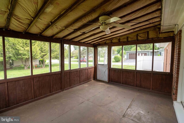 unfurnished sunroom with a ceiling fan and vaulted ceiling