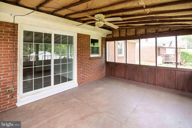 unfurnished sunroom with ceiling fan