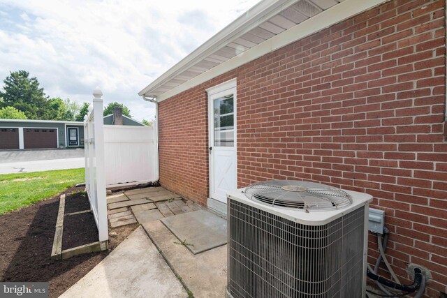 exterior view of central AC unit, brick siding, and fence