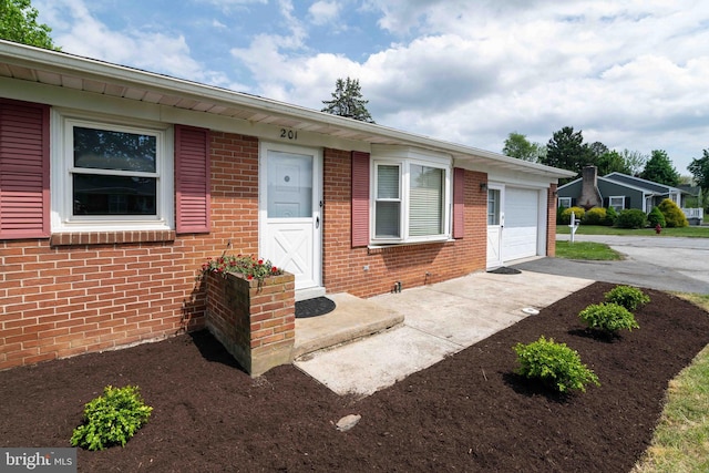 ranch-style house featuring driveway, brick siding, and an attached garage