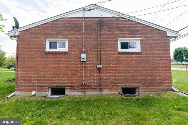 view of property exterior featuring a yard and brick siding