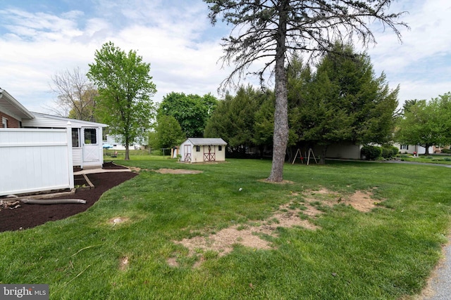 view of green lawn with a shed and an outbuilding