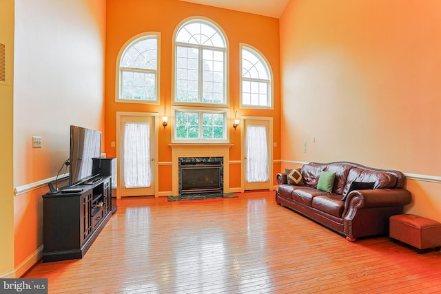 82 Granville Way, Exton, PA 19341 - living area featuring baseboards, a fireplace, a towering ceiling, and hardwood / wood-style flooring