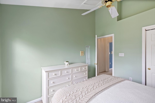 carpeted bedroom with baseboards, a towering ceiling, and a ceiling fan