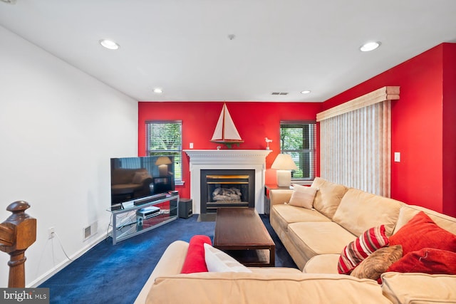 carpeted living room with a glass covered fireplace, recessed lighting, and baseboards
