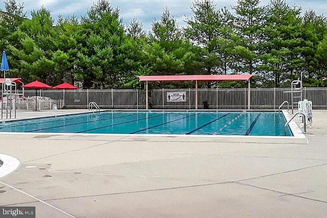 community pool featuring a patio and fence