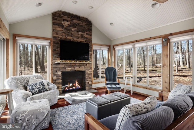 living area featuring lofted ceiling, a fireplace, and wood finished floors