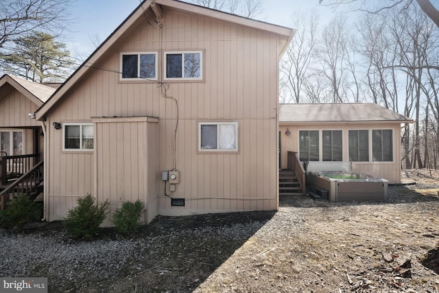 back of property featuring a shingled roof and a sunroom