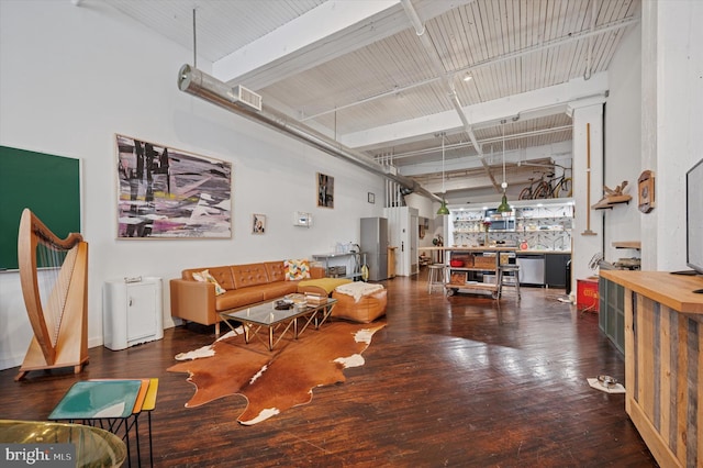 living area with hardwood / wood-style floors, visible vents, and a high ceiling
