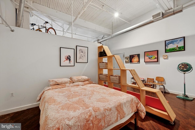 bedroom featuring track lighting, visible vents, wood finished floors, and baseboards