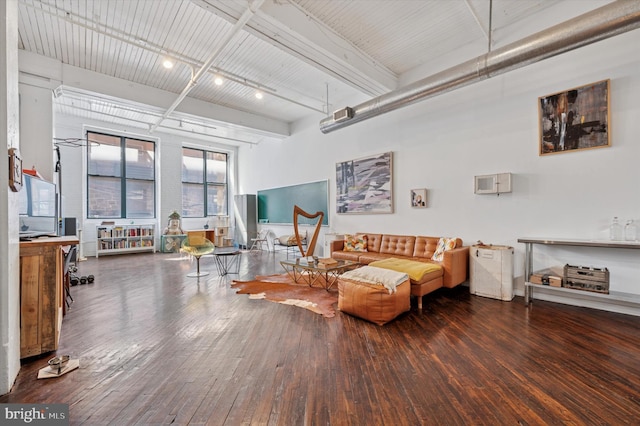living area featuring wood-type flooring and beam ceiling
