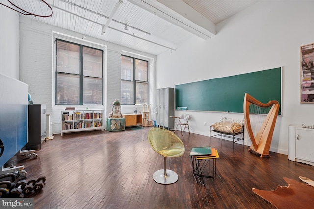 living area featuring beam ceiling and hardwood / wood-style floors