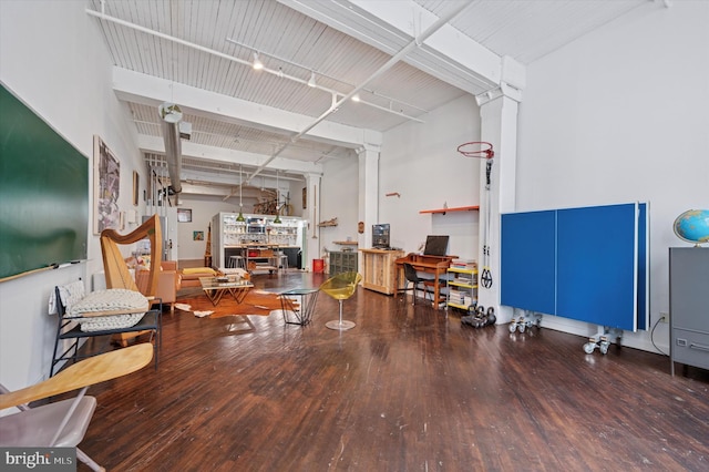 miscellaneous room featuring ornate columns and wood finished floors