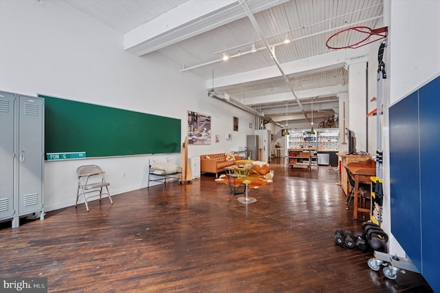 miscellaneous room with beamed ceiling, baseboards, and wood finished floors