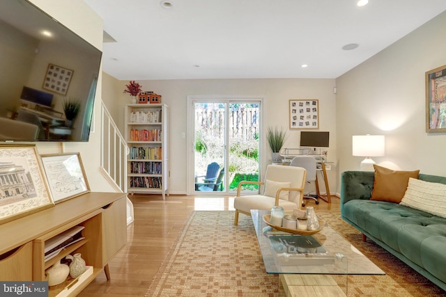 living area featuring stairs, baseboards, light wood-type flooring, and recessed lighting
