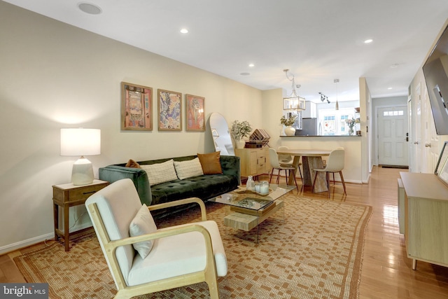 living room featuring recessed lighting, baseboards, and wood finished floors