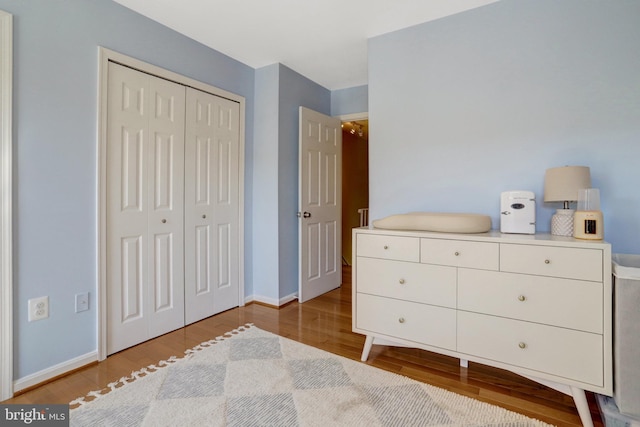 bedroom featuring baseboards, a closet, and wood finished floors
