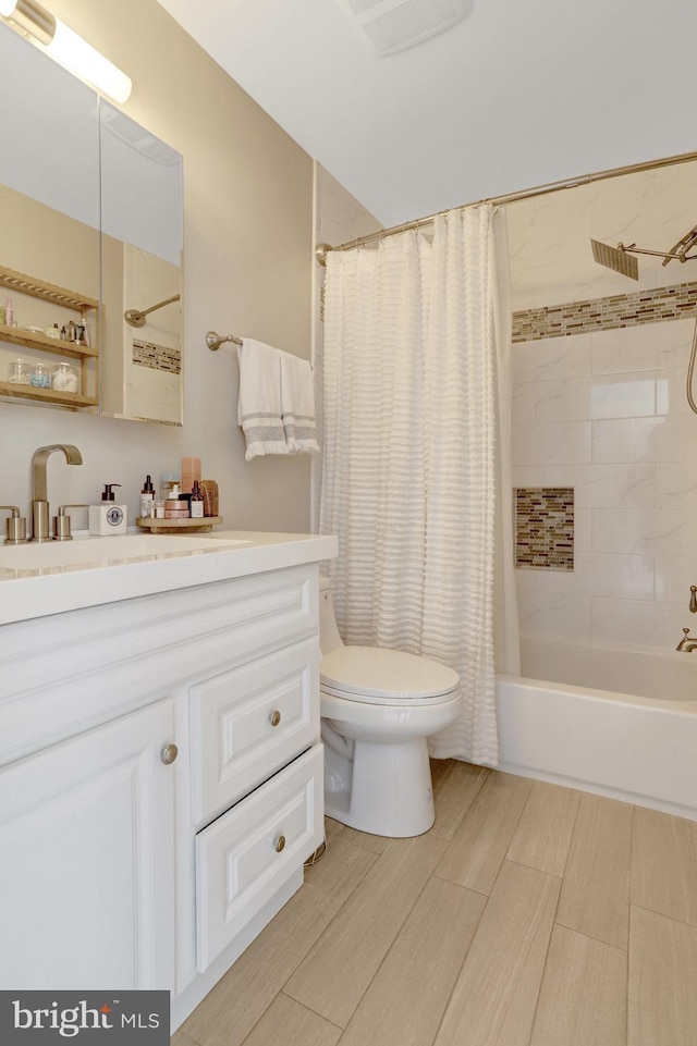 bathroom with toilet, wood finished floors, shower / bath combo with shower curtain, visible vents, and vanity