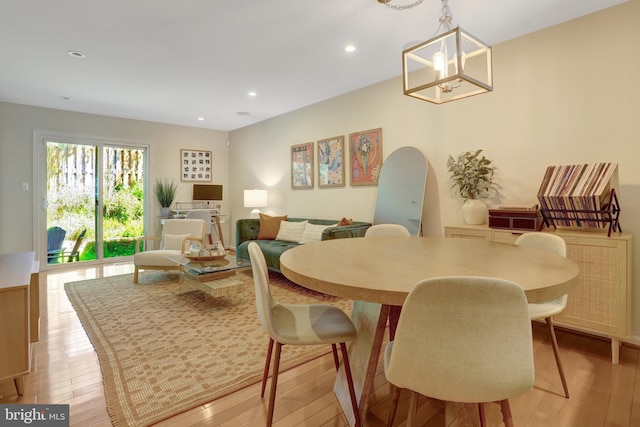 dining area featuring a notable chandelier, light wood finished floors, and recessed lighting