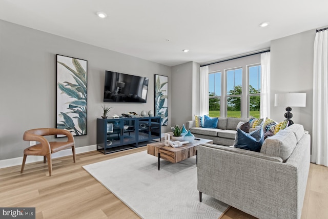 living area featuring recessed lighting, baseboards, and light wood-style floors