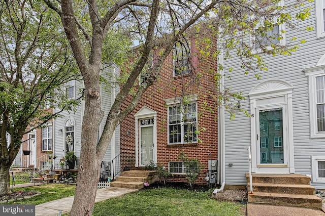 view of front of home featuring entry steps and brick siding