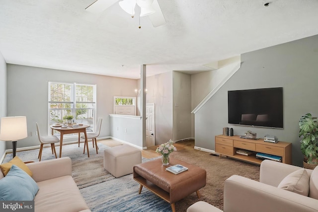 carpeted living room with baseboards and ceiling fan