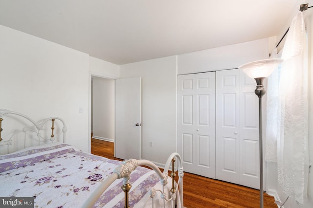 bedroom with wood finished floors and a closet