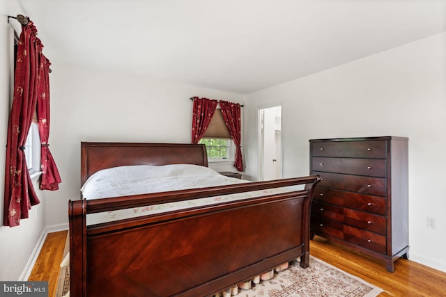 bedroom with wood finished floors and baseboards