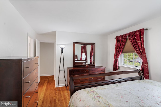 bedroom with wood finished floors and baseboards