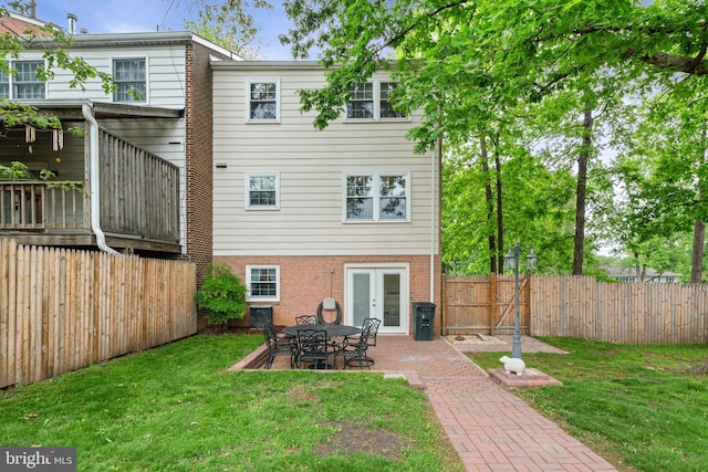 back of house with french doors, brick siding, and a patio area