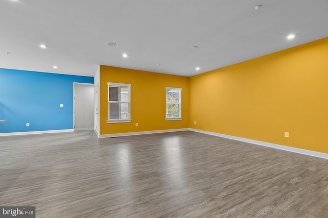 spare room featuring wood finished floors, baseboards, and recessed lighting