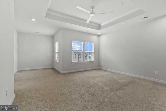 unfurnished room with a raised ceiling, ceiling fan, light colored carpet, baseboards, and recessed lighting
