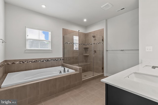 bathroom with a garden tub, a shower stall, tile patterned flooring, double vanity, and recessed lighting