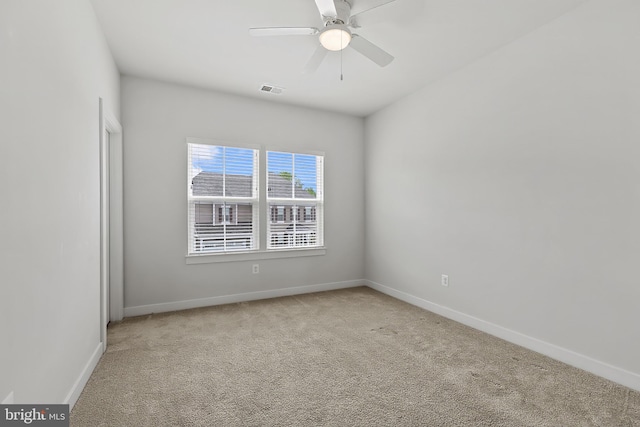 empty room featuring carpet flooring, baseboards, and a ceiling fan