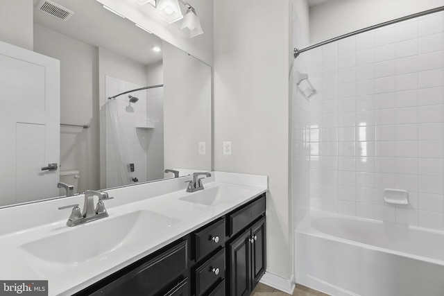 bathroom featuring toilet,  shower combination, and double vanity