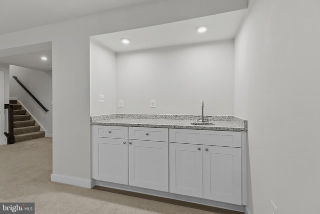 indoor wet bar featuring light carpet, stairway, recessed lighting, and baseboards