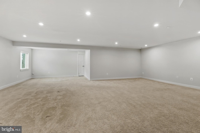 below grade area featuring recessed lighting, light carpet, and baseboards