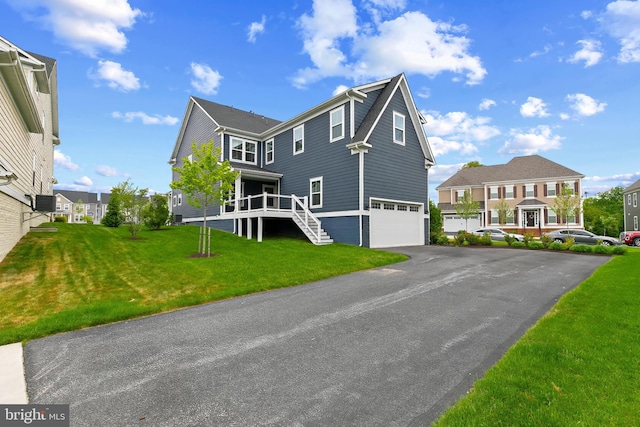 view of front of house featuring driveway, stairway, an attached garage, a front lawn, and a residential view