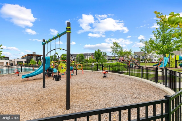 community play area featuring fence and a residential view