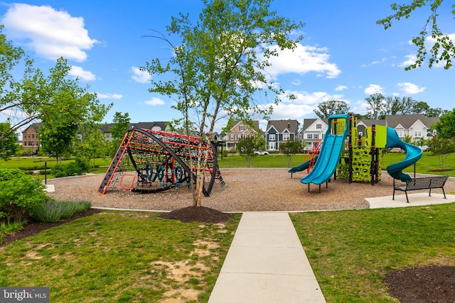 communal playground featuring a lawn and a residential view