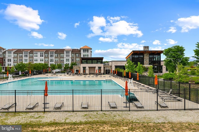 community pool with fence and a patio area