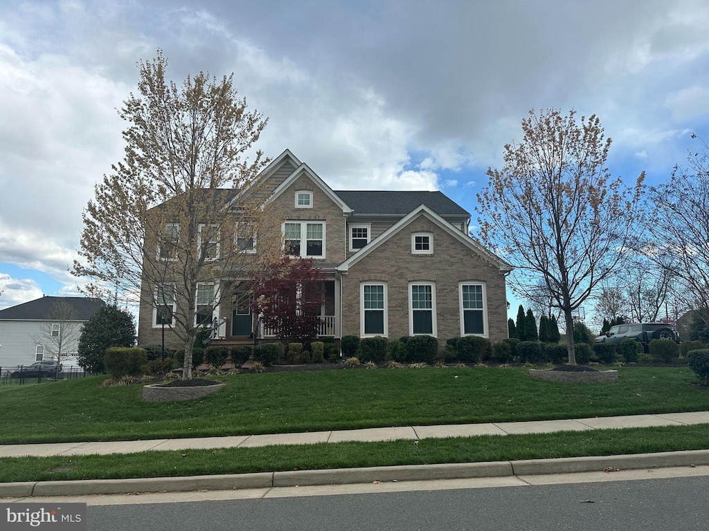 craftsman house featuring a front yard, a porch, and brick siding