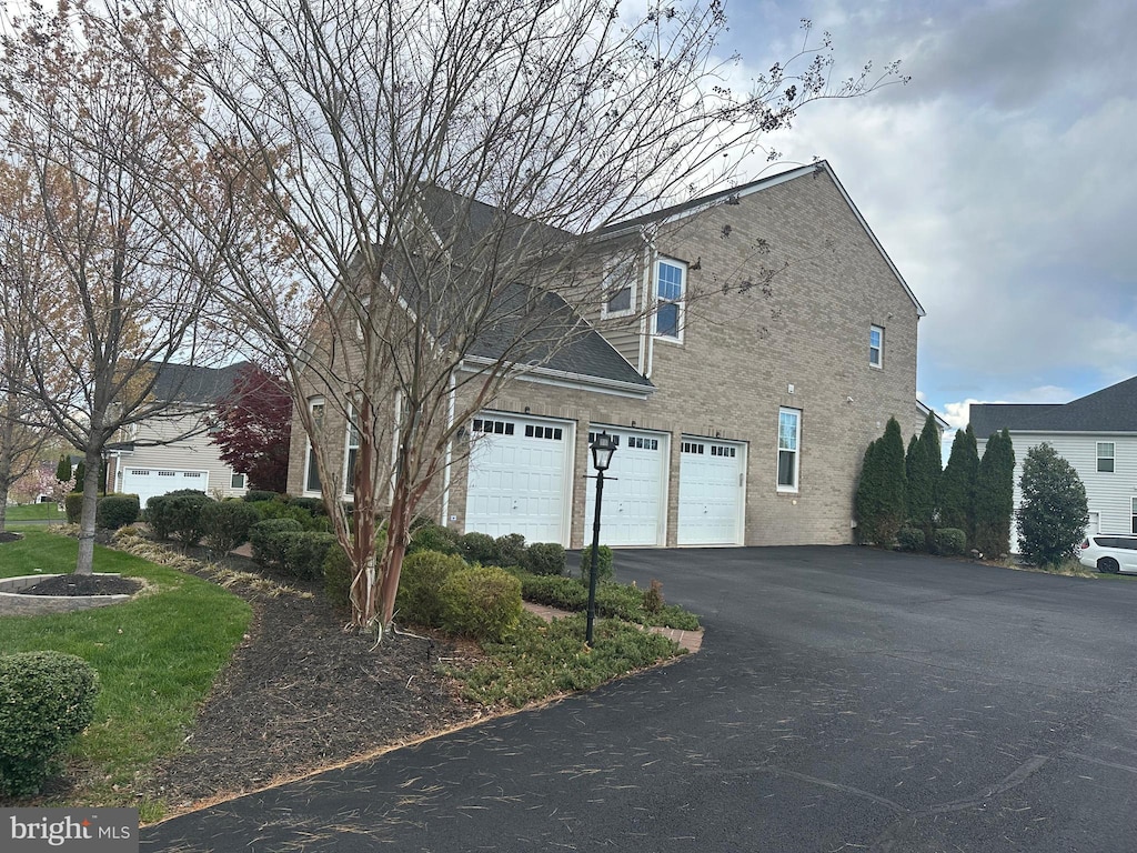 view of side of home with an attached garage and driveway