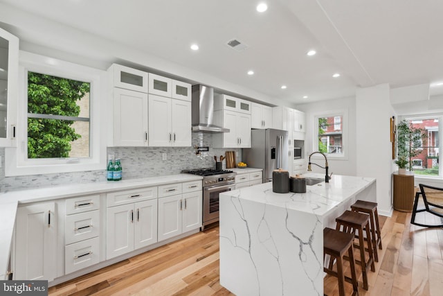 660 Columbia Rd NW, Washington, DC 20001 - kitchen featuring stainless steel appliances, a sink, wall chimney range hood, light wood finished floors, and recessed lighting