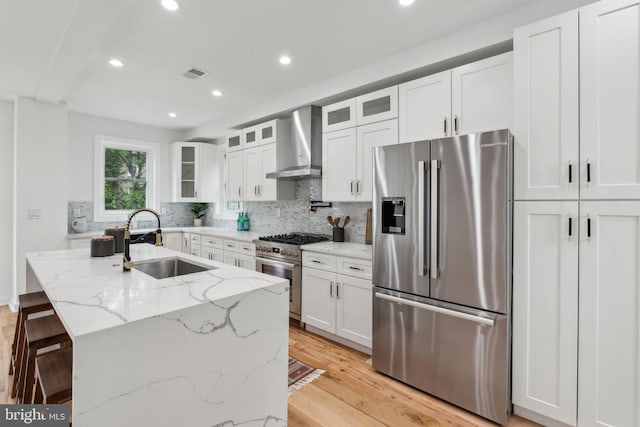 660 Columbia Rd NW, Washington, DC 20001 - kitchen featuring appliances with stainless steel finishes, wall chimney exhaust hood, a sink, backsplash, and white cabinets