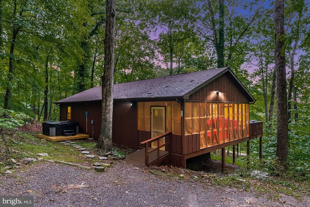 view of front facade featuring a hot tub and a deck